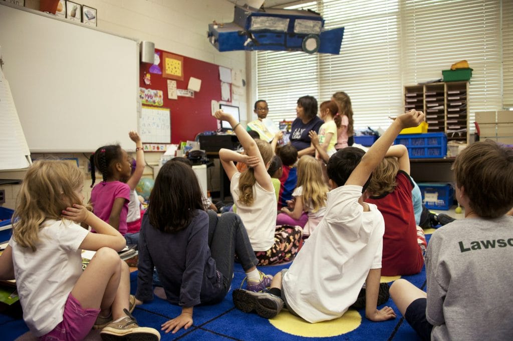 Childcare classroom busy teacher helping a young kids when short of staff